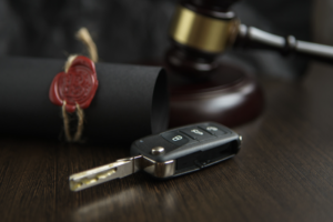 Close-up of a car key and a gavel on a table